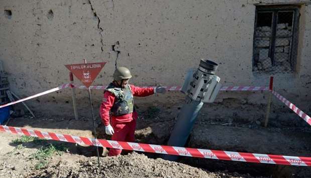 An officer shows a Smerch rocket before demining it in the village of Tap-Qaragoyunlu some 60 km from city of Ganja yesterday during the ongoing military conflict between Armenia and Azerbaijan over the breakaway region of Nagorno-Karabakh