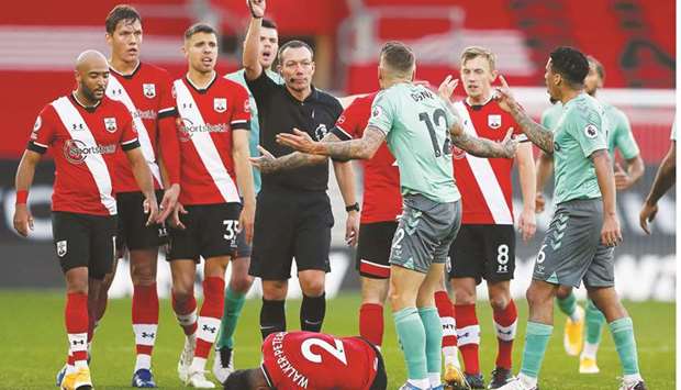 Evertonu2019s French defender Lucas Digne (3R) receives a red card from English referee Kevin Friend (C) for a foul on Southamptonu2019s English defender Kyle Walker-Peters (down) during their English Premier League match in Southampton yesterday.