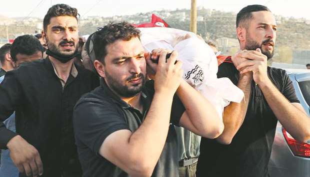 Palestinian mourners carry the body of 18-year-old Amer Abdel-Rahim Sanouber, who died following a confrontation with Israeli troops, during his funeral in the village of Yatma in the occupied West Bank, yesterday.