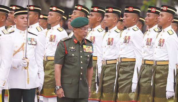 Malaysiau2019s King, Al-Sultan Abdullah inspects a guard of honour.