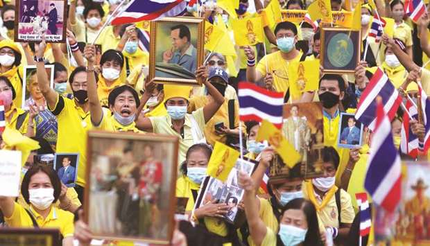 Royalists wearing yellow shirts wave Thailandu2019s flags during an event to support the monarchy in Bangkok yesterday.