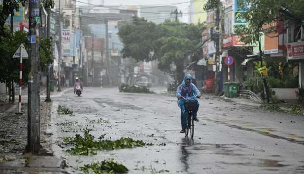 A man rides along a deserted road amid strong winds in central Vietnam's Quang Ngai province, as Typhoon Molave makes landfall