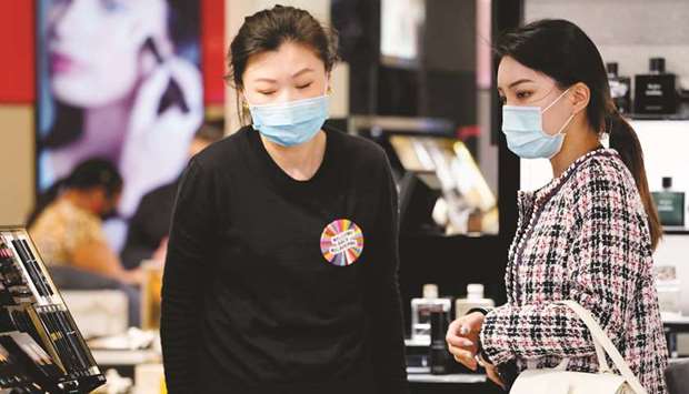 A shopper wearing a face mask is assisted in a retail store after Covid-19 restrictions were eased for the state of Victoria, in Melbourne, yesterday.