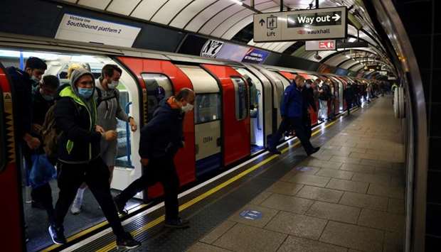 Commuters get out of an underground line, amid the outbreak of the coronavirus disease  in London.