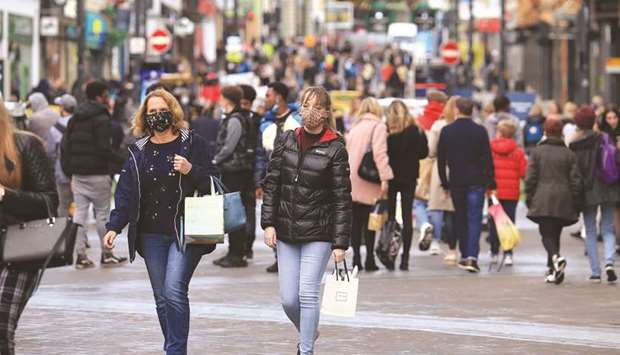 Shoppers walk wearing face masks in the centre of Leeds, West Yorkshire, northern England, yesterday, as the area prepares to be placed in the strictest u2018very highu2019 tier of restrictions from November 2 to combat the coronavirus pandemic.