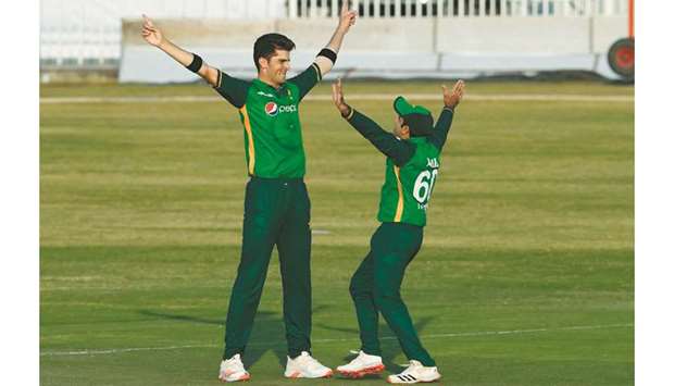Pakistanu2019s Shaheen Afridi (L) celebrates with teammate Abid Ali after the dismissal of Zimbabweu2019s Brian Chari during their first one-day international (ODI) cricket match at the Rawalpindi Cricket Stadium in Rawalpindi yesterday.