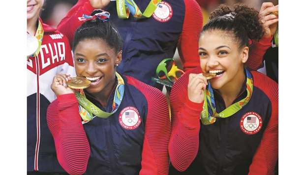 Laurie Hernandez (right) and Simone Biles of USA pose with their gold medals on the podium after winning the womenu2019s team final at 2016 Rio Olympics. (Reuters)