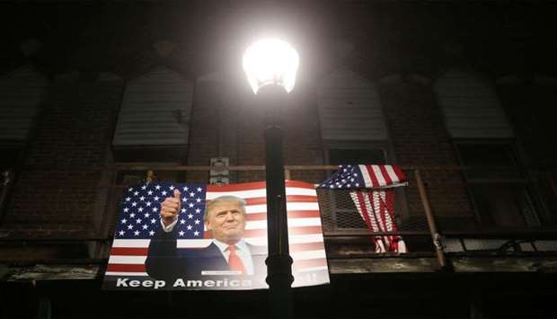 A poster of President Donald Trump is displayed along a street in Winterset, Iowa.