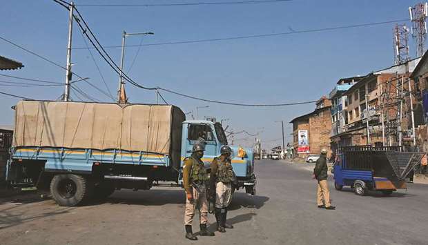 Government forces stand guard at a check point during a one-day strike called by the All Parties Hurriyat Conference (APHC) against the government decision to open Kashmir land for all people, in Srinagar yesterday.