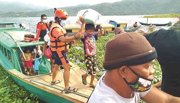 A handout photo taken yesterday from the Facebook page of Philippine Coast Guard, shows personnel evacuating residents from the coastal villages of Buhi town, Camarines Sur province, south of Manila, to a safer place, ahead of Typhoon Goniu2019s landfall.