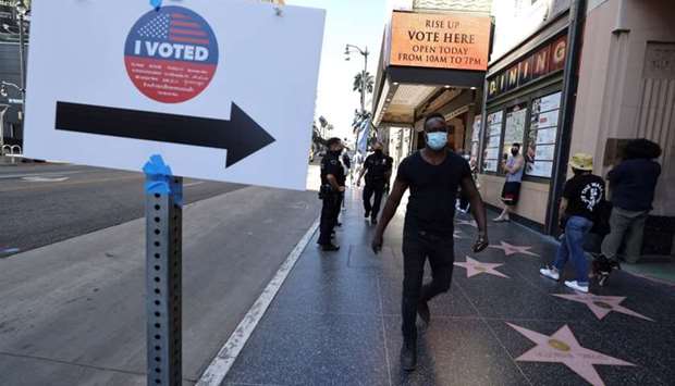 People walk on Hollywood Boulevard outside the Pantages Theater polling station, during the global outbreak of the coronavirus disease, in Hollywood, Los Angeles, California