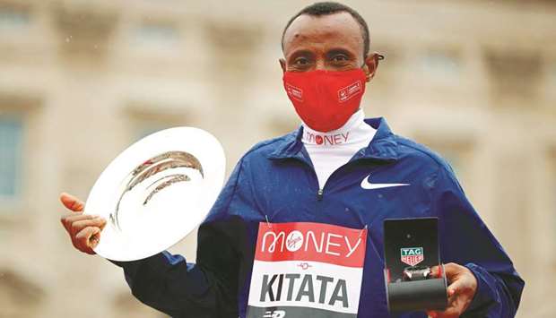 Ethiopiau2019s Shura Kitata poses with his trophy in front of Buckingham Palace after winning the menu2019s race of the 2020 London Marathon yesterday. (AFP)