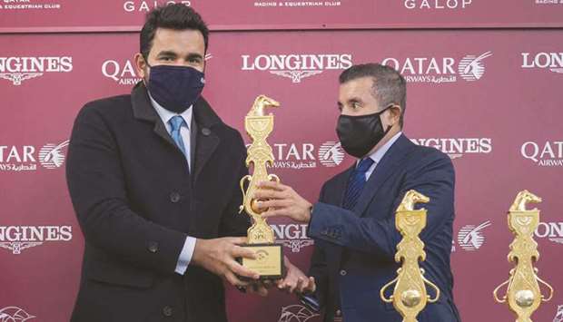His Highness Sheikh Mohamed bin Khalifa al-Thani (right) receives the Qatar Arabian World Cup (Group 1 PA) trophy on behalf of His Highness Sheikh Abdullah bin Khalifa al-Thani from HE Sheikh Joaan bin Hamad al-Thani (left) after Tayf won the 2,000m race at ParisLongchamp yesterday.