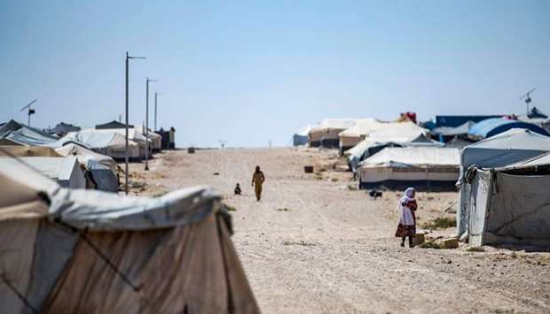 People walk past tents in the Kurdish-run al-Hol camp in the al-Hasakeh governorate in northeastern Syria, where families of Islamic State (IS) foreign fighters are held on August 25.