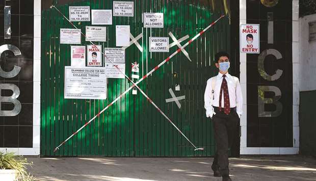 Safety measure: A student wearing a facemask leaves a school sealed by authorities as some teachers and students tested positive for the Covid-19 coronavirus in Islamabad yesterday.