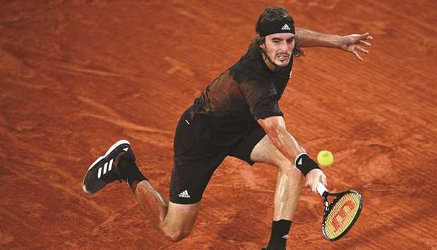 Greeceu2019s Stefanos Tsitsipas returns the ball to Bulgariau2019s Grigor Dimitrov (not pictured) during their French Open fourth round match at Roland Garros in Paris, France, yesterday. (AFP)