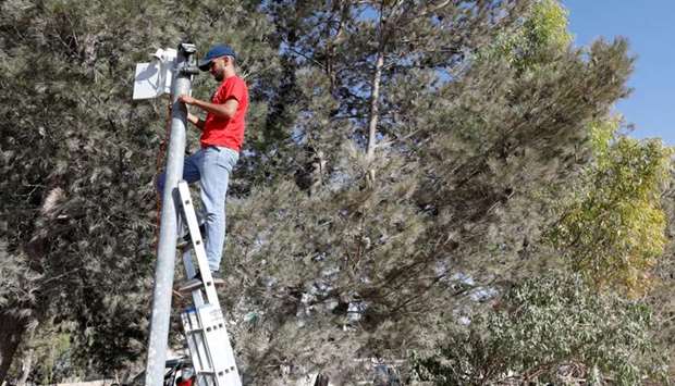 A worker installs a video surveillance system to keep an eye on nearby Israeli settlers who Palestinians accuse of frequent attacks, in the village of Kisan in the Israeli-occupied West Bank