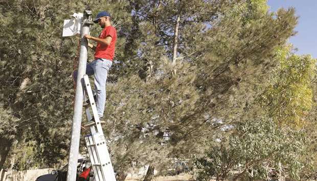 A worker installs a video surveillance system to keep an eye on nearby Israeli settlers who Palestinians accuse of frequent attacks, in the village of Kisan in the occupied West Bank.