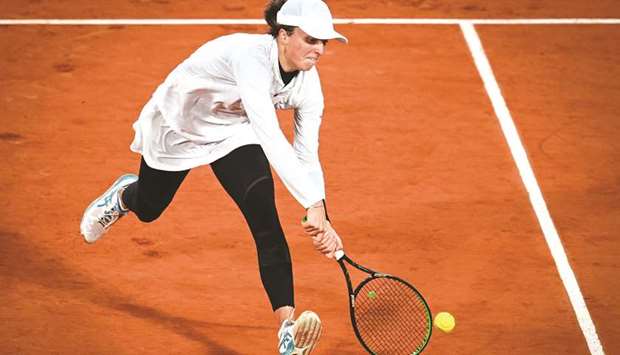 Polandu2019s Iga Swiatek returns the ball to Italyu2019s Martina Trevisan (not pictured) during their French Open quarter-final at Roland Garros in Paris, France, on Tuesday. (AFP)