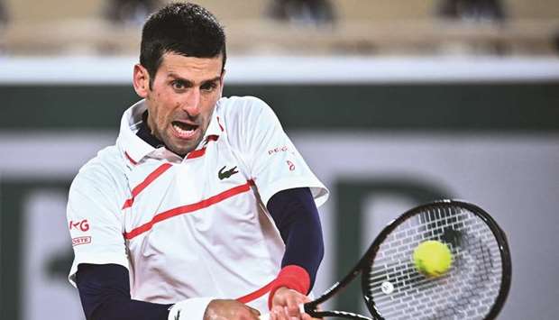 Serbiau2019s Novak Djokovic returns the ball to Spainu2019s Pablo Carreno Busta (not pictured) during their French Open quarter-final at Roland Garros in Paris, France, yesterday. (AFP)
