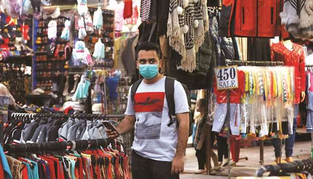 PROTECTION: A man wearing a protective mask pauses in a market in Karachi.  Reuters