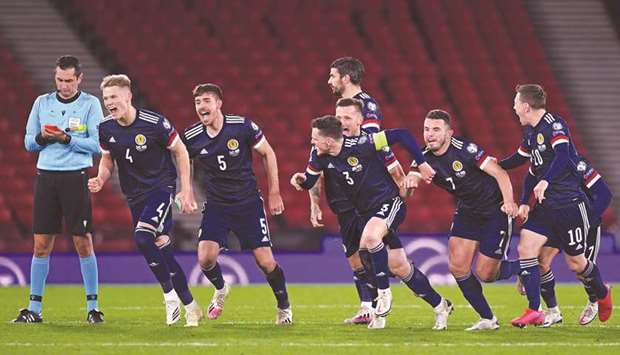 Scotlandu2019s players run to celebrate after winning the penalty shootout against Israel during the Euro 2020 playoff semi-final at Hampden Park, Glasgow. (AFP)