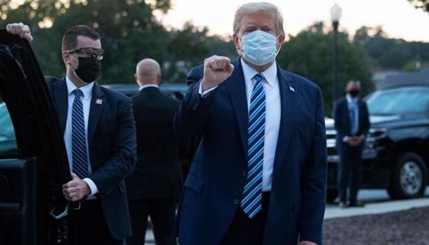 In this file photo taken on October 05, US President Donald Trump pumps his fist as he leaves Walter Reed Medical Center in Bethesda, Maryland heading towards Marine One, to return to the White House after being discharged