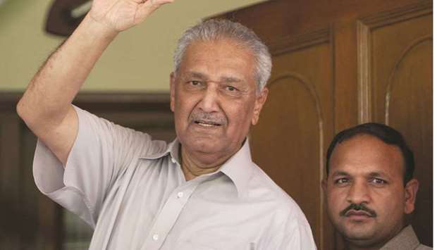 Abdul Qadeer Khan waves to journalists from the front door of his house in Islamabad in 2009