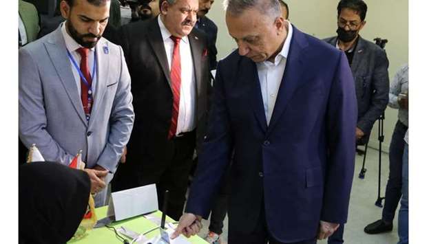 Iraqi Prime Minister Mustafa Al-Kadhimi casts his vote at the polling station at the Green Zone in Baghdad, as Iraqis go to the polls to vote in the parliamentary election. REUTERS