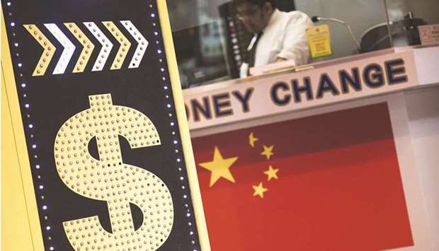 A sign displaying the Hong Kong dollar and Chinese yuan currency signs sits outside a currency exchange store in China. The US currencyu2019s surge is helping the yuan record its largest gain in eight months on a trade-weighted basis in September, a Bloomberg replica of the official CFETS RMB Index shows.