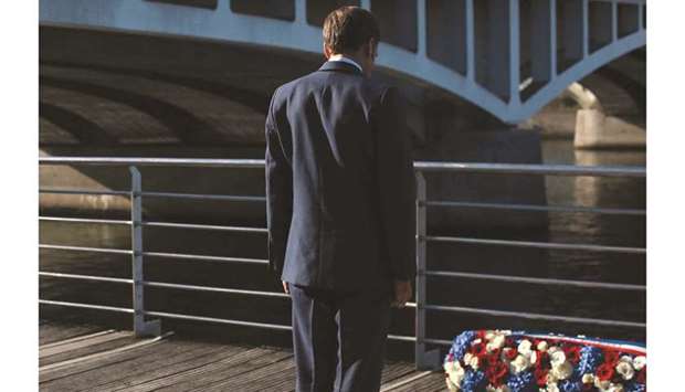French President Emmanuel Macron stands at attention after laying a wreath near the Pont de Bezons (Bezons Bridge) in Colombes, near Paris, yesterday. (AFP)