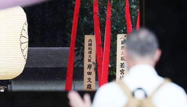 A wooden plaque showing the name of Japan's Prime Minister Fumio Kishida is seen with a ,masakaki, tree that he sent as an offering to the controversial Yasukuni Shrine on the first day of autumn festival in Tokyo.  JIJI PRESS / AFP