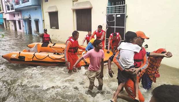 Members of National Disaster Response Force (NDRF) evacuate people to safer places from a flooded area in Udham Singh Nagar in the northern state of Uttarakhand, India, yesterday.