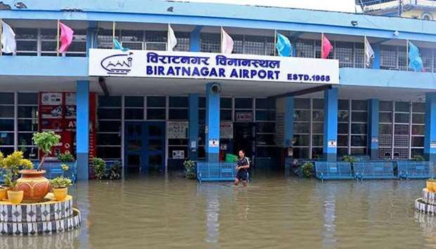 A man wades through the flooded entrance of a domestic airport after heavy rain in Biratnagar, Nepal. (AFP)