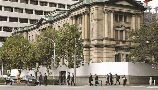 Pedestrians cross a road in front of the Bank of Japan headquarters in Tokyo. The BoJ is discussing phasing out a Covid-19 loan programme if infections in the country continue to dwindle, sources said, potentially setting the bank up to exit a key crisis-mode policy sooner than investors expect.