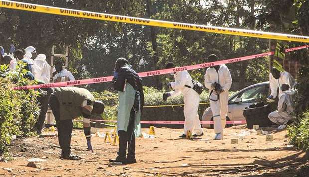 Ugandan police officers investigate at a crime scene following a bomb blast on Saturday night in Kampala, yesterday.