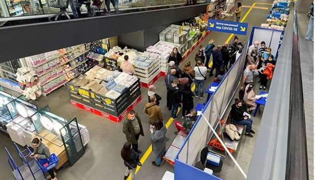 People wait to receive a vaccine against the coronavirus disease at a vaccination centre opened in a construction supplies hypermarket in Kyiv, Ukraine. REUTERS