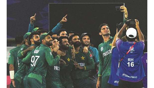 Pakistanu2019s Shaheen Shah Afridi takes a selfie along with his teammates after winning the ICC menu2019s Twenty20 World Cup against India at the Dubai International Cricket Stadium in Dubai on Sunday. (AFP)