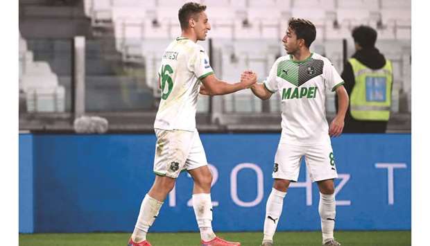 Sassuolou2019s Davide Frattesi (left) celebrates with Sassuolou2019s French Maxime Lopez after opening the scoring during the Italian Serie A match against Juventus in Turin. (AFP)
