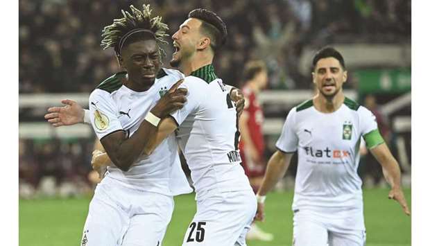 Moenchengladbachu2019s Kouadio Kone (left) celebrates with teammates after scoring against Bayern Munich during the German Cup second round match in Moenchengladbach, western Germany, on Wednesday. (AFP)