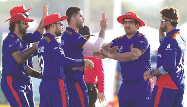 Afghanistanu2019s Naveen-ul-Haq (centre) celebrates with teammates after taking the wicket of Namibiau2019s Michael van Lingen (not pictured) during the ICC menu2019s Twenty20 World Cup match at the Sheikh Zayed Cricket Stadium in Abu Dhabi yesterday. (AFP)