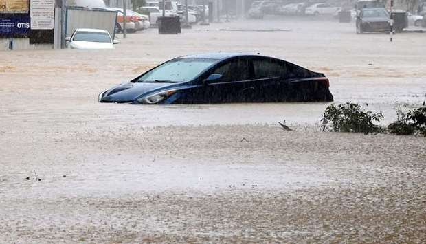 A car is partially submerged on a flooded street as Cyclone shaheen makes landfall in Muscat Oman.
