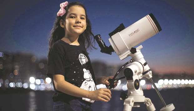 Astronomer Nicole Oliveira poses for a picture with her telescope.