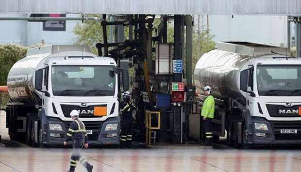 Workers fill up oil tanks at the Esso fuel services in Purfleet, Britain yesterday. REUTERS