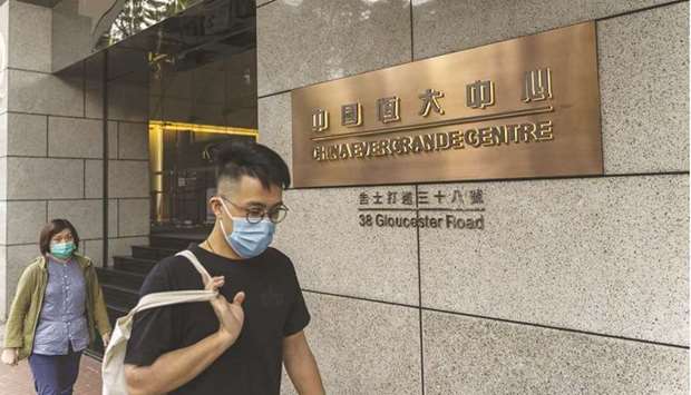 Pedestrians walk past the China Evergrande Centre in Hong Kong. Chinese property firms may face a wave of defaults next year if Evergrande Groupu2019s deepening debt crisis shuts access to a key source of funding and conditions donu2019t ease for heavily indebted borrowers.