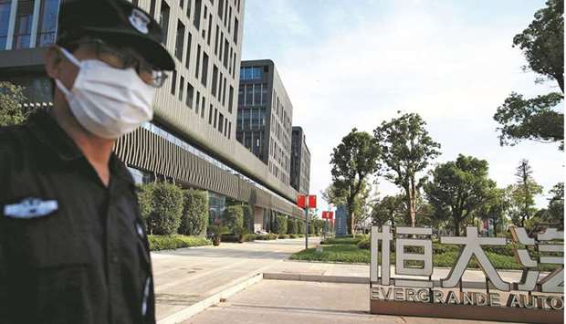 A security guard stands outside the Evergrande Automotive R&D Institute Headquarters in Shanghai (file). Evergrandeu2019s situation is complex not just because of the humongous debt pile, but also because the restructuring will affect jurisdictions including China, Hong Kong, the Cayman Islands and New York.