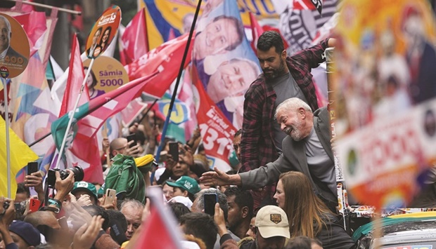 Lula greets supporters as he leads a silent march in Sao Paulo yesterday.