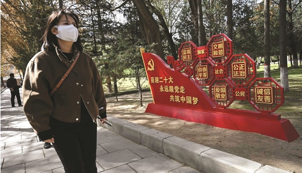 A tourist walks past an installation welcoming the 20th Communist Party Congress in Yanu2019an city, in Chinau2019s northwest Shaanxi province yesterday. As Chinau2019s leaders gather for a crucial party congress, the country is expected on Tuesday to announce some of its weakest quarterly growth figures since 2020, its economy hobbled by Covid restrictions and a real estate crisis.