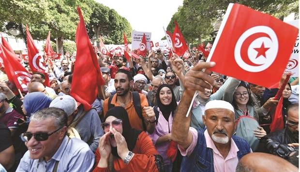 Supporters of the Tunisian Ennahda party wave national flags and raise placards during a demonstration against President Kais Saied in the capital Tunis, yesterday.