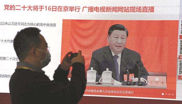 A journalist takes a photo of a screen showing Chinese President Xi Jinping at the press centre ahead of Chinau2019s 20th Communist Party Congress in Beijing yesterday.